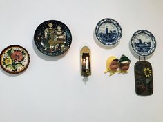 four plates and two candle holders on a wall