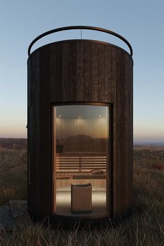 a round wooden structure sitting on top of a grass covered field