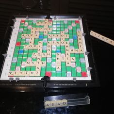 a scrabble board with words on it and two pieces of wood next to it