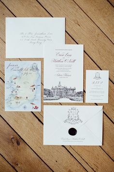 the wedding stationery is laid out on a wooden table