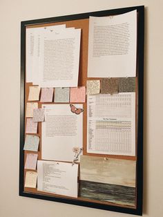 a bulletin board with several papers pinned to it's side and attached to the wall