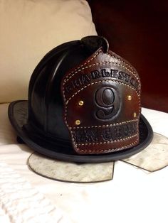 a black leather hat sitting on top of a bed