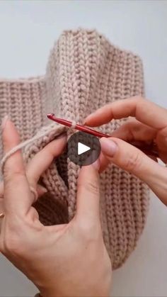 two hands crocheting the ends of a sweater