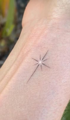 a small star tattoo on the left side of the arm, with an arrow in the center