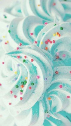 a close up view of a cake with white frosting and sprinkles