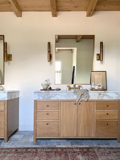 a bathroom with two sinks and mirrors on the wall