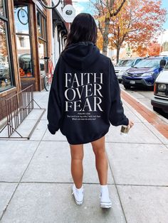 "Faith Over Fear Hoodie \"The Lord is on my side, I will not fear. What can man do unto me?\" Psalm 118:6 A simple \"what does your hoodie mean\" could change someone's life. We are meant to go out and make disciples of all nations & this shirt could help you start the conversation🤍 This would make a great Christian gift for anyone who loves Jesus and wants to spread the gospel. To get the trendy oversized look like the model in the picture, use the size chart and order a size or two larger than your normal size. Our Mission: To provide trend HIGH QUALITY Apparel meant to spread the Gospel and bring others to the kingdom of Heaven. Wear your Faith. Q U I C K * F A C T S * *50% cotton/ 50% polyester fabric blend *Runs true to size. *If you would like an oversized fit, be sure to order 1-3 Christian Clothing, Bible Verse, Black Hoodie, Summer Collection, Zip Hoodie, San Jose