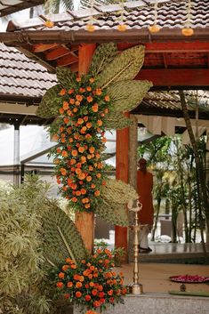 orange flowers and greenery are hanging from the roof