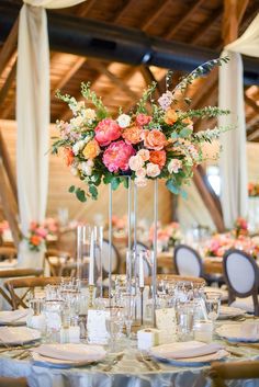 the centerpieces on this table are filled with pink and orange flowers