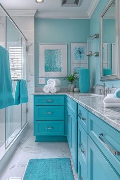 a bathroom with blue cabinets and marble counter tops in the center, along with towels hanging on the wall