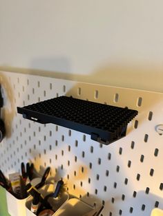 there is a shelf made out of legos on the wall with scissors and other office supplies