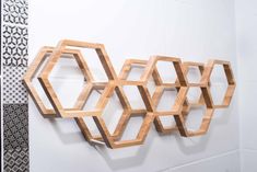 a wall sculpture made out of wooden hexagons on a white tiled wall