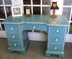 a blue desk with two drawers and a lamp