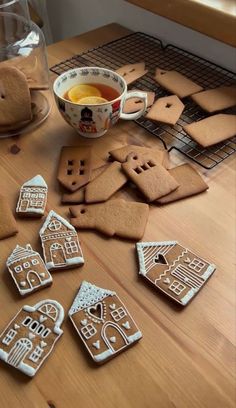 gingerbread cutouts are arranged on a table next to a bowl of orange juice