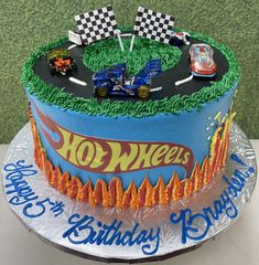 a birthday cake decorated with hot wheels and race cars