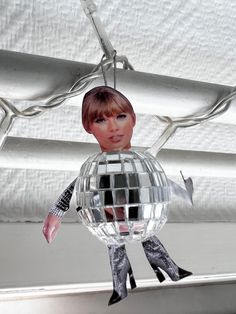 a mirror ball ornament hanging from the ceiling with a woman's face on it