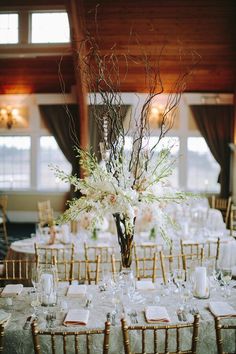 an elegant centerpiece with white flowers and greenery