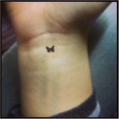 a small butterfly tattoo on the side of a woman's right arm and leg