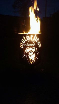 a lighted sign that is on fire in the dark with a man's face