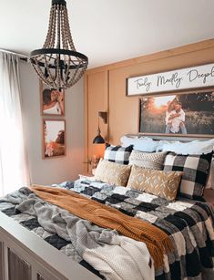 a bedroom with a bed, chandelier and pictures on the wall above it