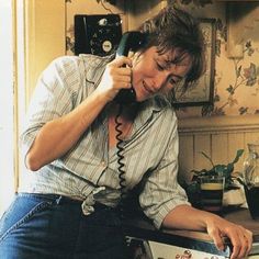 a woman talking on the phone while sitting at a desk