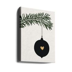 a black and gold christmas ornament hanging from a tree branch with a heart on it