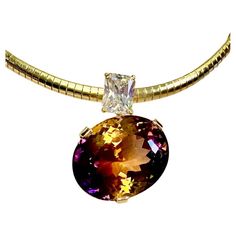 Ametrine is paired with white sapphire in this one-of-a-kind Due Gemme pendant. Ametrine (origin: Bolivia) is an unusual bi-color form of quartz, half amethyst and half citrine, thus the name ametrine. This gem is a wapping 54.55 carats. More common ametrine shows yellow on one end and purple on the other. This gem shows purple on both ends and a broad streak of yellow through the center. It is faceted and polished in a flashy portuguese cut. Supporting the gem and concealing the bail is a radia Ametrine Jewelry, Gem Show, Radiant Cut, White Sapphire, Citrine, Original Design, Jewelry Necklace Pendant, Violet, Sapphire