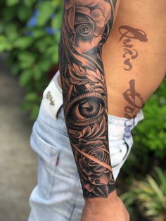 a man's arm with tattoos on it and an eye in the middle is shown