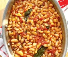 a pot filled with beans and spinach on top of a table