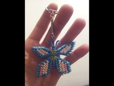 a hand holding a small butterfly shaped keychain