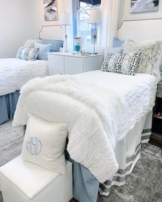 two twin beds in a bedroom with blue and white decor on the bedding, along with matching throw pillows