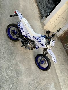 a white and blue motorcycle parked next to a building