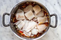 fish fillets in a pot on a marble counter top