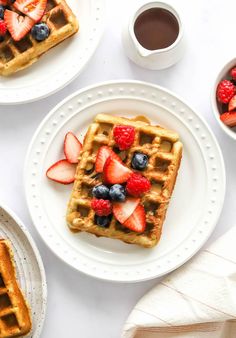 three waffles with strawberries, blueberries and raspberries on them