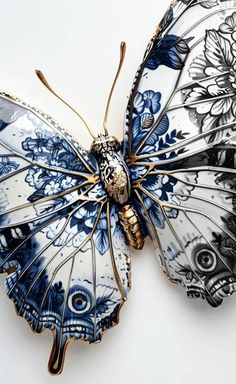 a blue and white butterfly brooch sitting on top of a piece of art paper