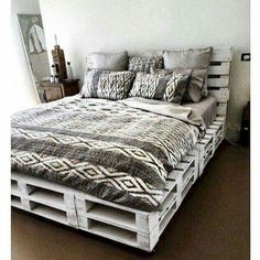 a bed made out of wooden pallets and pillows