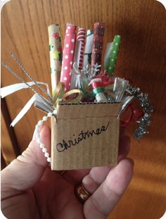 a person holding a small box filled with candy canes