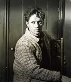 an old black and white photo of a woman in a sweater sitting on a chair