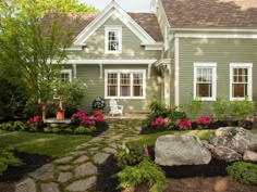 a house with flowers and rocks in the front yard