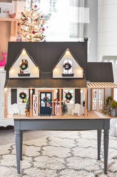 a doll house with christmas decorations on the roof