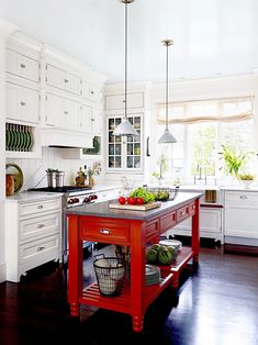 a kitchen with white cabinets and red island