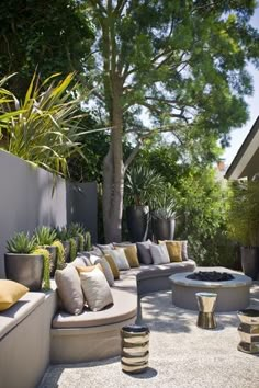 an outdoor seating area with potted plants and large round couches in the foreground