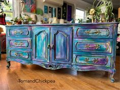 an old dresser painted in blue and purple