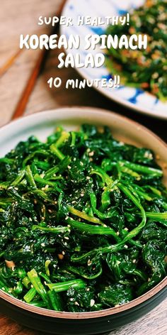 a bowl filled with green vegetables on top of a wooden table next to another plate