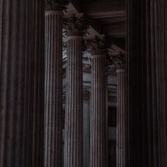 an image of columns in the middle of a building with clock on it's side