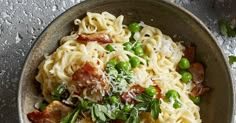 a bowl filled with pasta, peas and bacon