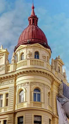 an old building with a red dome on top and a flag flying in the foreground