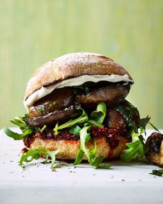 a sandwich with mushrooms and greens on it