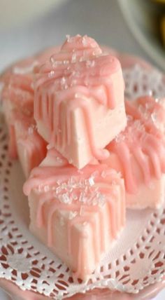 three pieces of pink candy sitting on top of a white plate