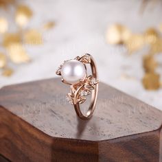 a pearl ring sitting on top of a wooden box